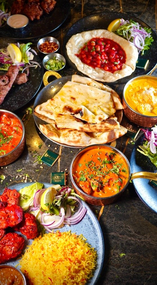 Freshly Cooked Indian Food Chef cooking with flames rising from the pan