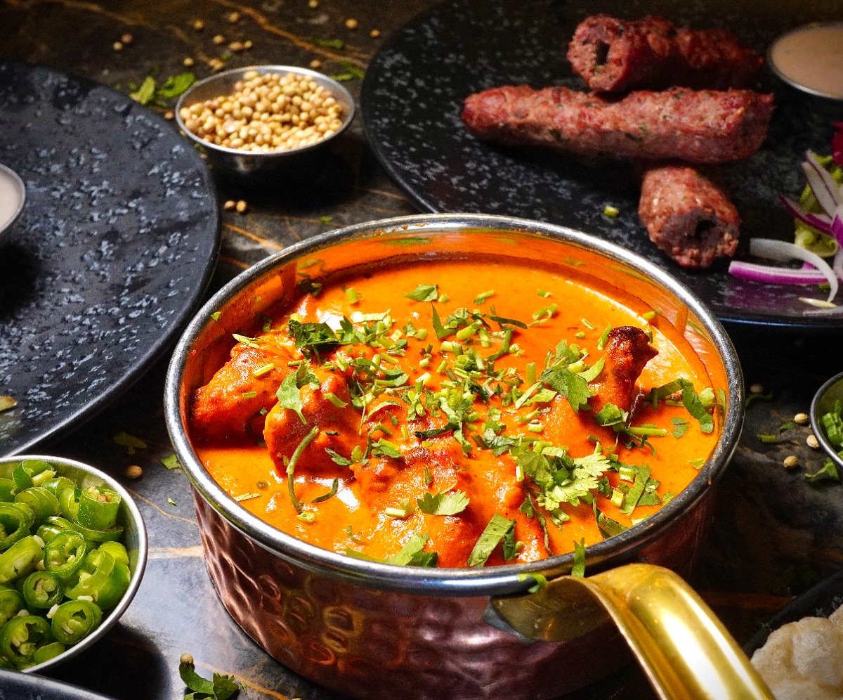 Best Curry from Sanam Tandoori, Falkirk Curry in a black bowl resting on a wooden board.